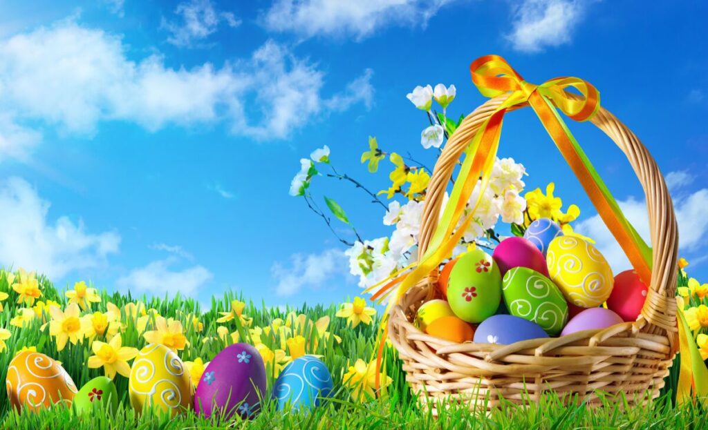 A basket of colorful eggs in the grass.