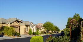 A street with many houses and trees on the side.