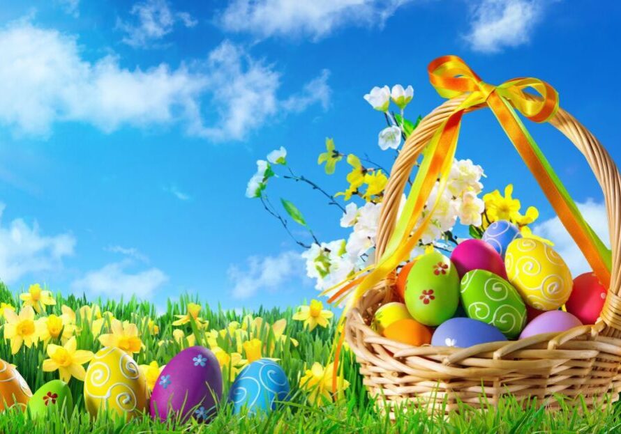 A basket of colorful eggs in the grass.